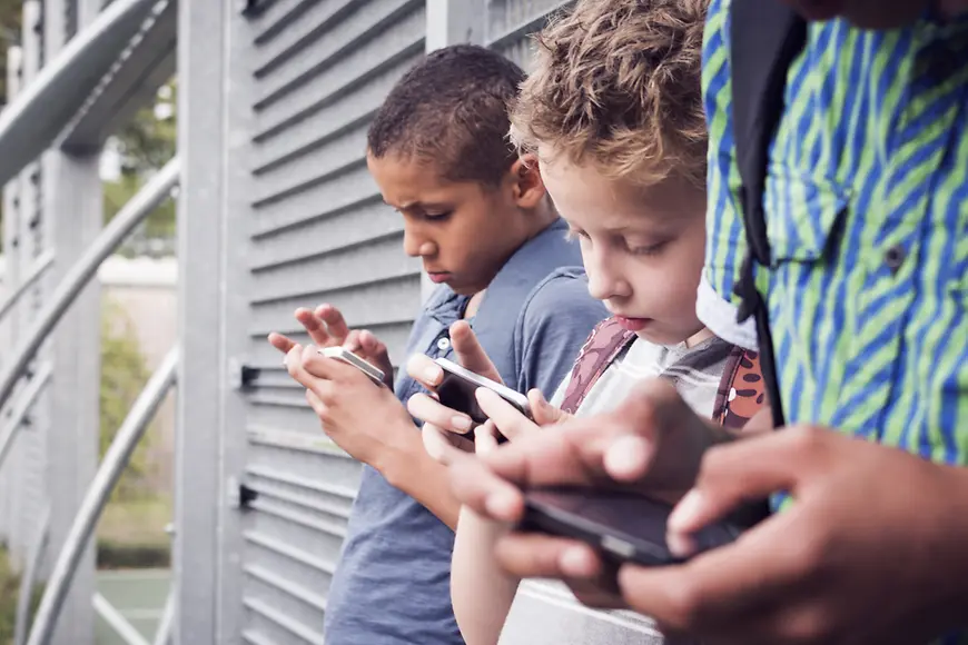 Drei Jugendliche benutzen Smartphones