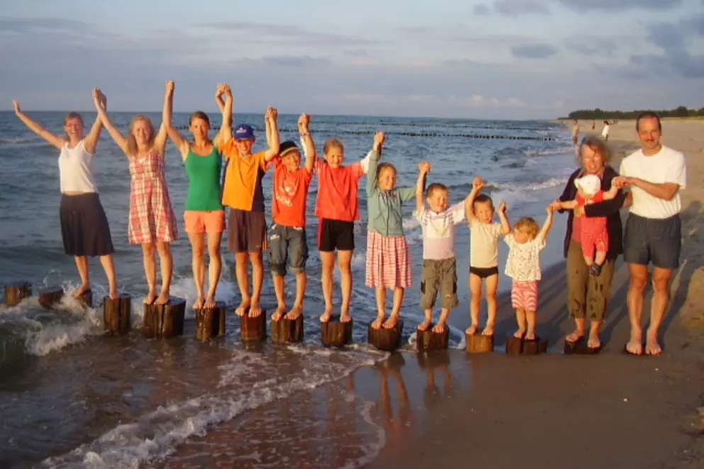 Eltern mit zwölf Kindern am Strand