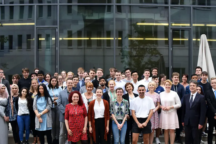 Ein Gruppenbild mit etwa 80 Personen im Innenhof des Ministeriums