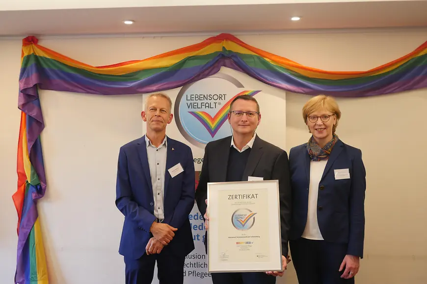 Das Bild zeigt drei Menschen, die die Auszeichnung in Form eines Zertifikats präsentieren