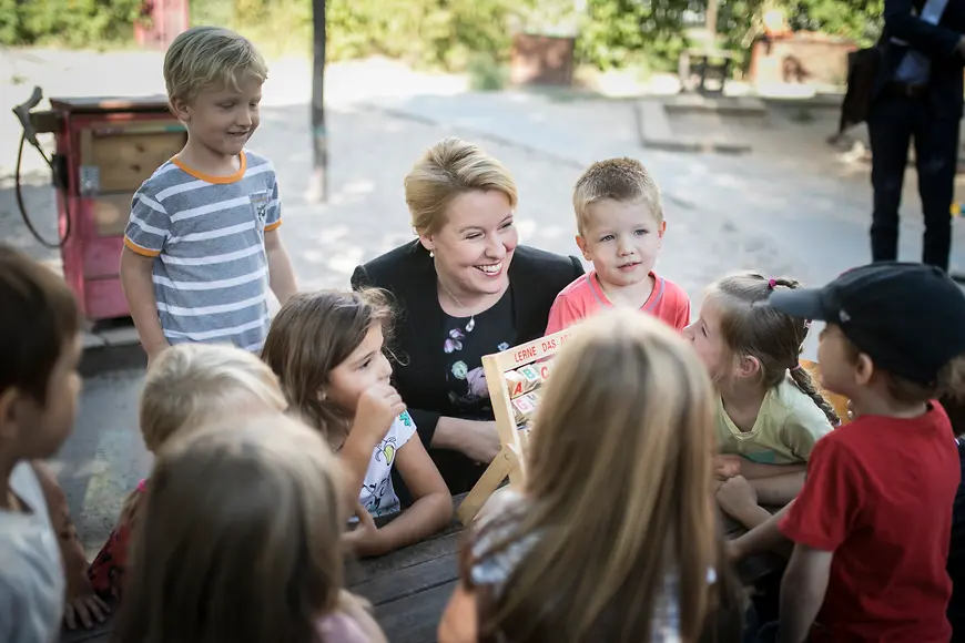 Das Bild zeigt Franziska Giffey umringt von Kindern