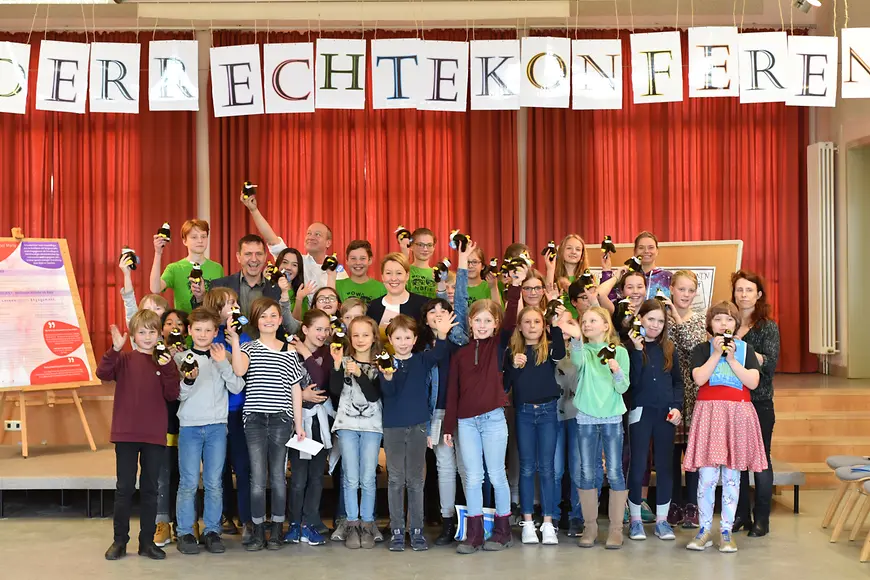 Das Bild zeigt Dr. Franziska Giffey mit Kindern für ein Gruppenbild posierend