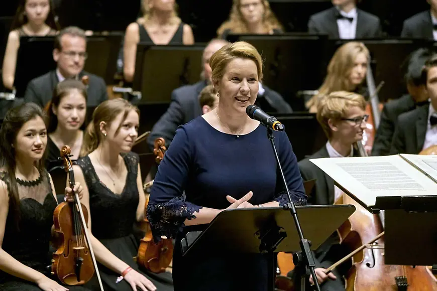Das Bild zeigt Dr. Franziska Giffey bei einer Rede vor Jugendlichen mit Instrumenten