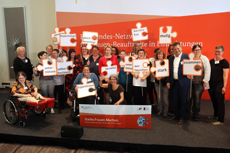 Eine Gruppe von Menschen mit Schildern und einem Banner mit der Aufschrift: Starke Frauen Machen