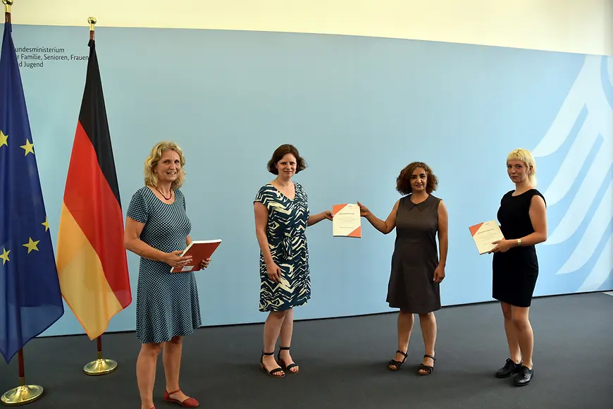 Vier Frauen bei der Übergabe des Dokuments