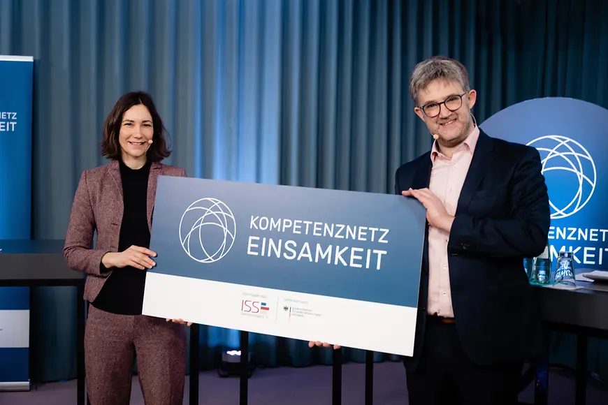 Anne Spiegel und Benjamin Landes halten eine Tafel hoch mit der Aufschrift Kompetenznetz Einsamkeit