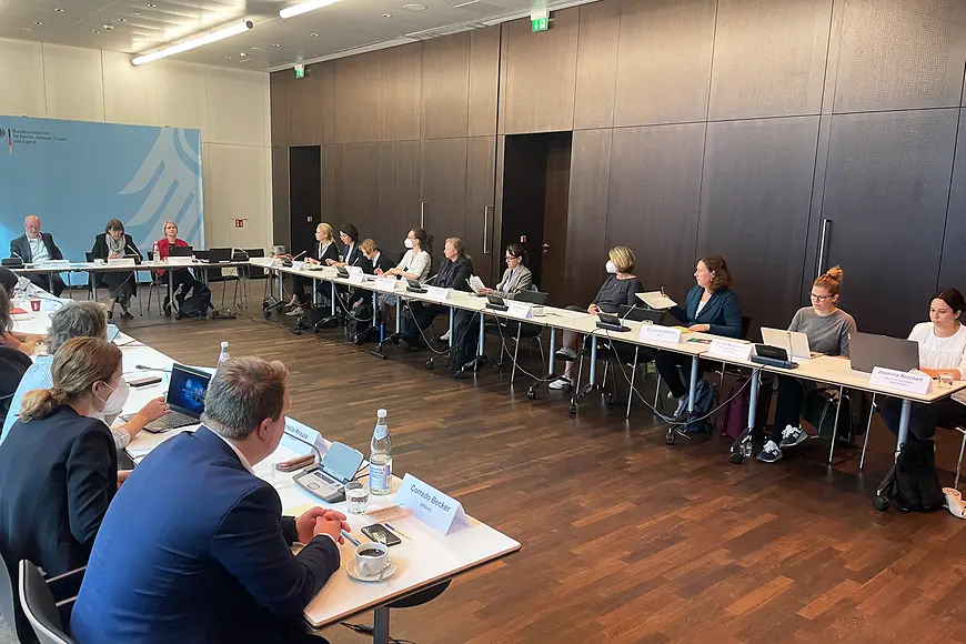 Ein Konferenzraum im Ministerium, die Mitglieder der interministeriellen Arbeitsgruppe sitzen in einer Runde an Tischen.