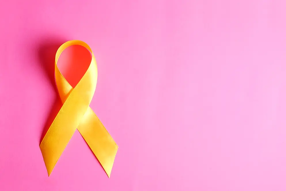 Gelbe Schleife auf pinkfarbenem Untergrund