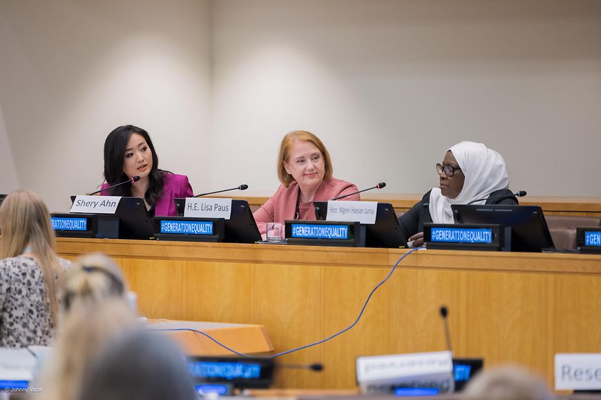 Lisa Paus sitzt mit anderen Teilnehmenden auf einem Podium