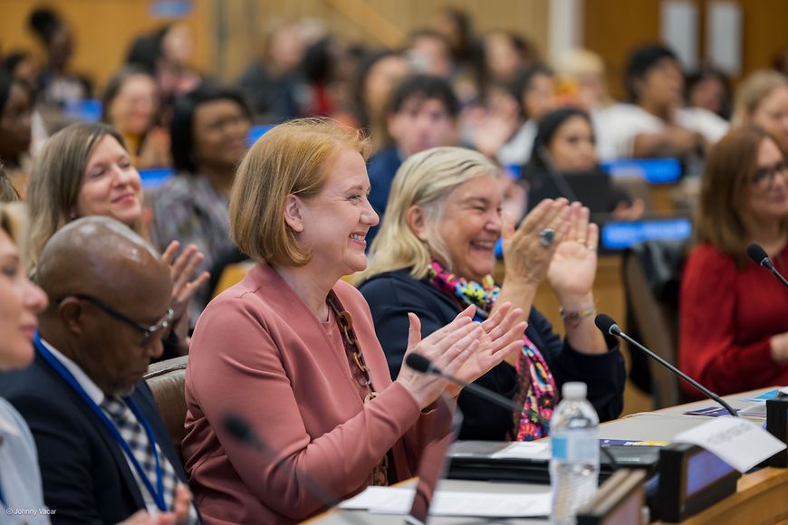 Lisa Paus sitzt mit anderen Teilnehmenden auf einem Podium