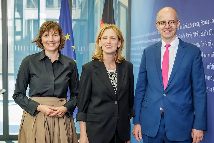 Karin Prien mit Mareike Wulf und Michael Brand vor einer Wand mit Urkunden 