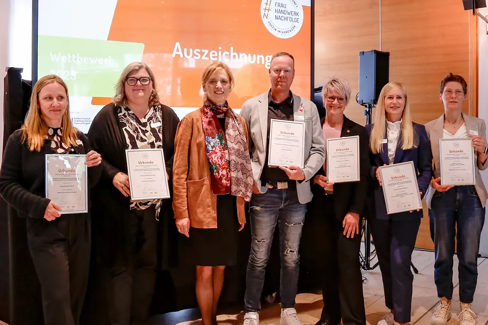 Gruppenfoto von Karin Prien und anderen vor Leinwand
