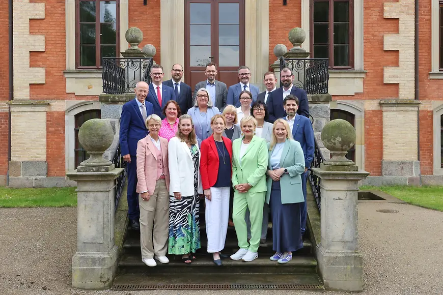 Karin Prien sitzt mit den Teilnehmenden der Bildungsministerkonferenz an einem Tisch