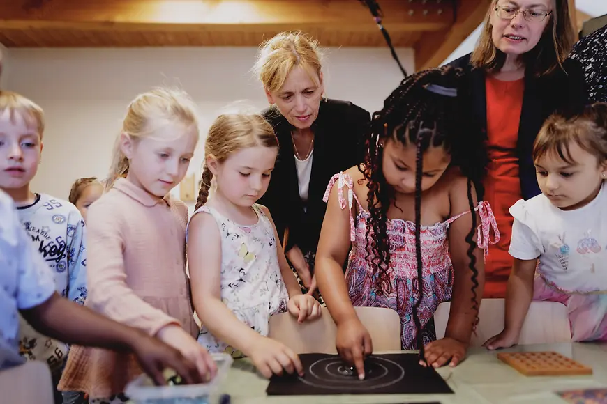 Karin Prien und Sascha Karolin Aulepp unterhalten sich mit Kindern 