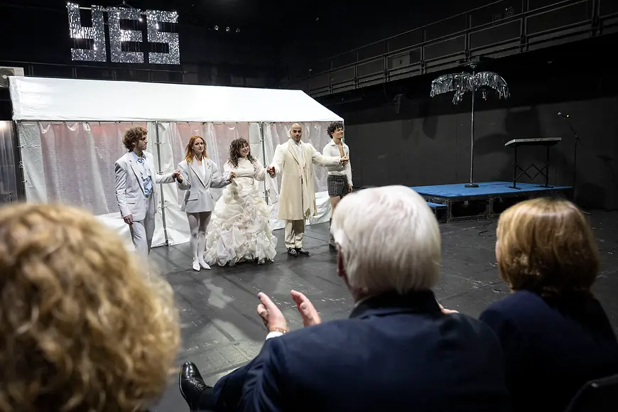 Auf einer Bühne bedankt sich eine Gruppe von Schauspielern für den Applaus