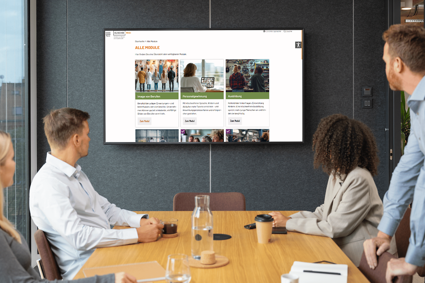 Eine Gruppe Personen blickt auf einen Bildschirm