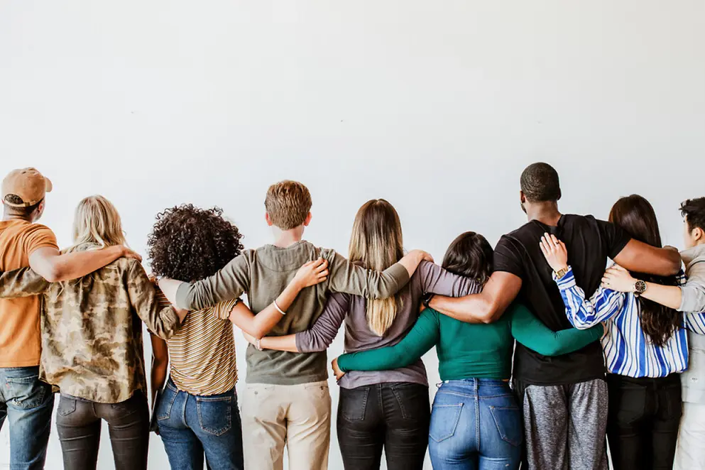 Rückansicht einer Gruppe von Menschen mit verschiedenen Hautfarben, die Arm in Arm in einer Reihe stehen