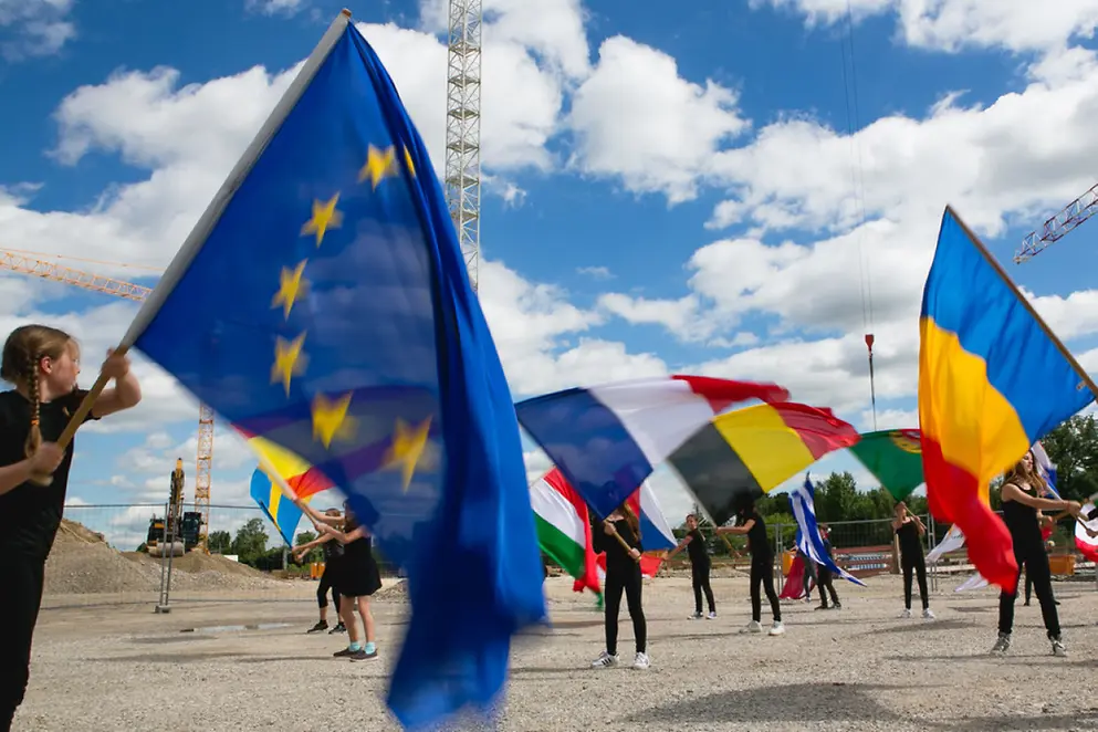 Mehrere Kinder schwenken verschiedene europäische Flaggen im Freien