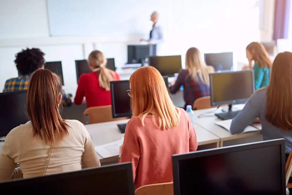 Jugendliche sitzen gemeinsam in einem Computerraum der Schule