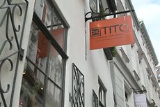 Hausansicht mit Schmiedeeisernen Elementen und einem hängenden Ladenschild