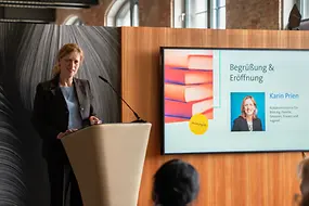 Karin Prien an einem Rednerpult vor Menschen