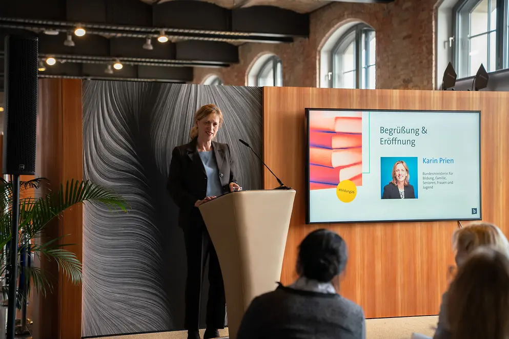 Karin Prien an einem Rednerpult vor Menschen