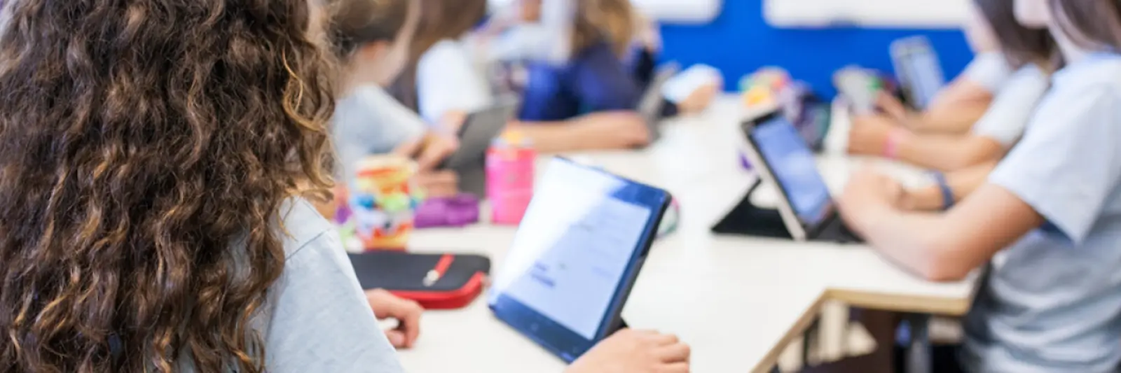 In einem Klassenraum arbeiten Kinder an Tablets