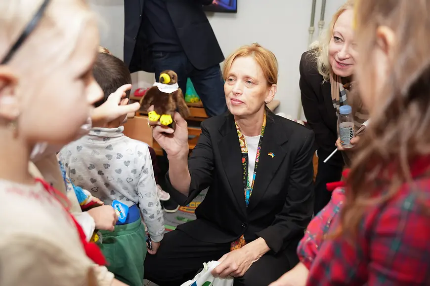 Karin Prien überreicht Kindern ein Kuscheltier