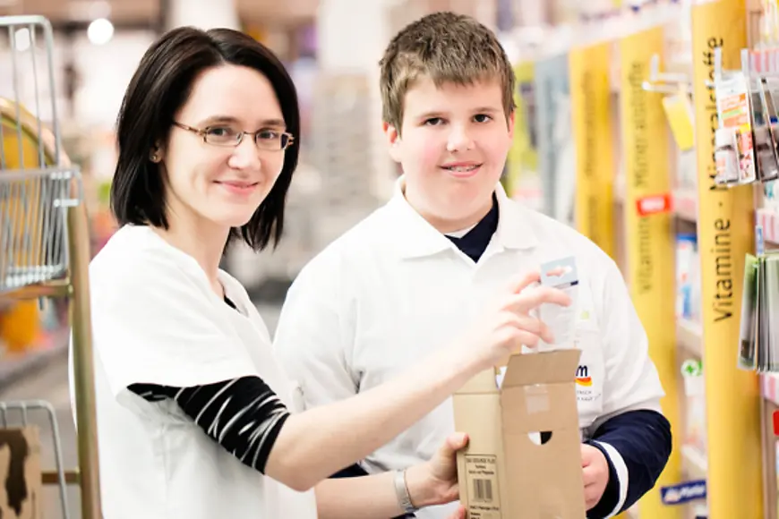 Frau und Junge in einer Drogeriefiliale am Regal