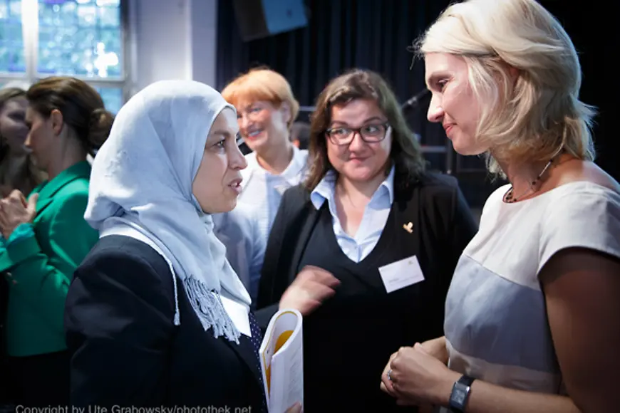 Manuela Schwesig im Gespräch mit einer Frau, die ein Kopftuch trägt