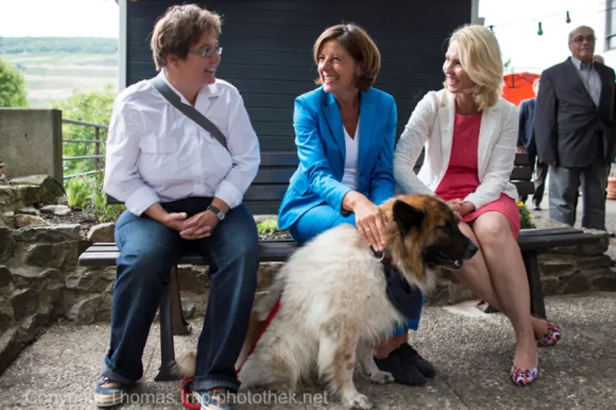 Manuela Schwesig und Malu Dreyer streicheln einen Besuchshund des Malteser Hilfsdiensts
